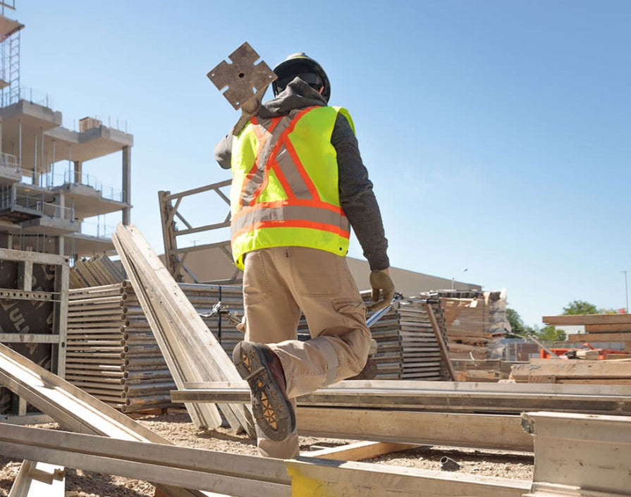 Wearing safety shoes to avoid workplace related injuries.